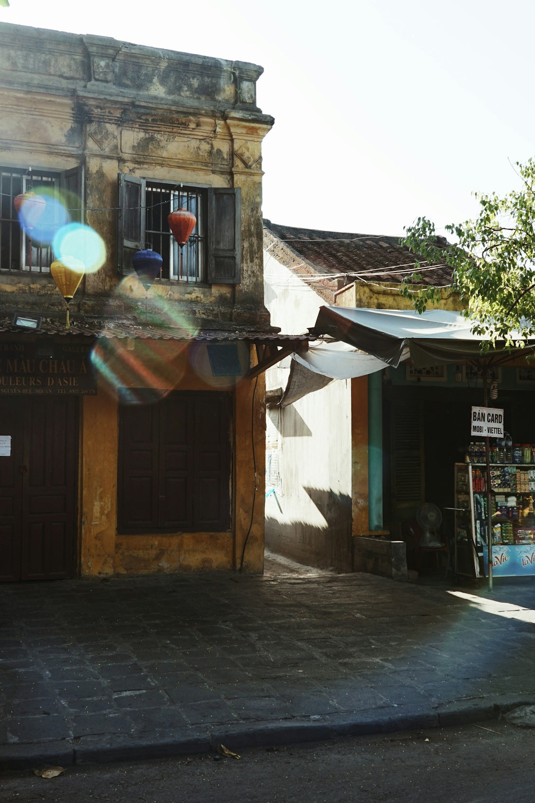 brown concrete building with green and yellow outdoor lantern
