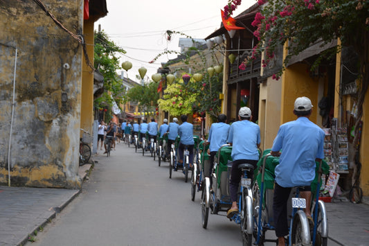 people in green shirts riding bicycle on street during daytime