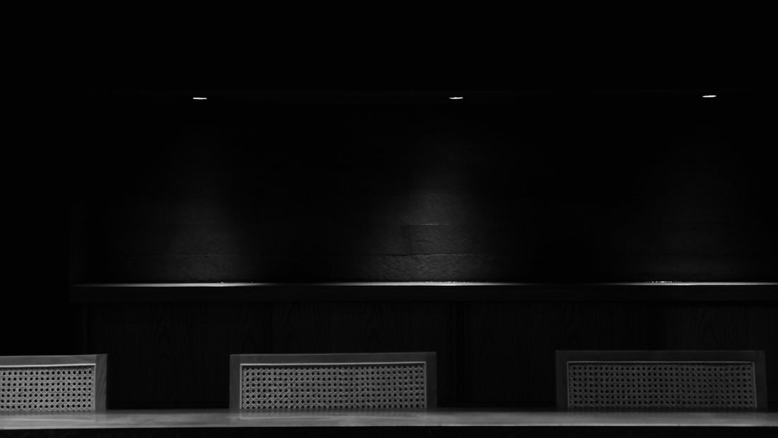 a black and white photo of a bench in a dark room