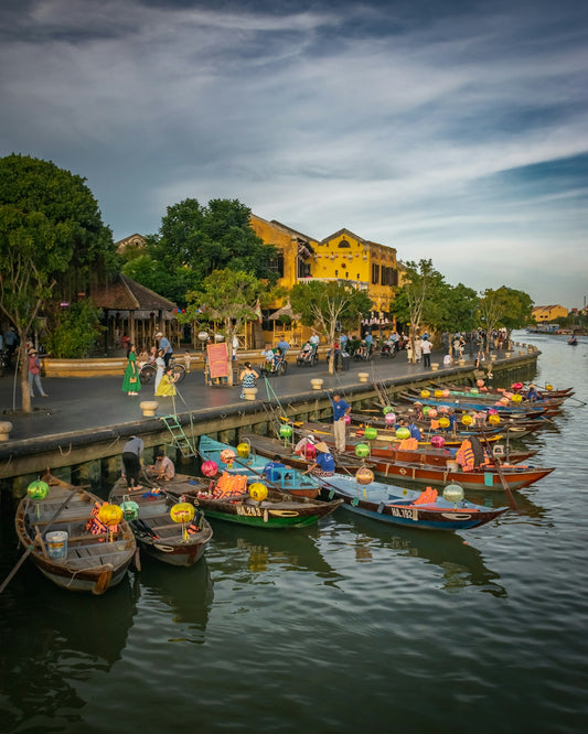 a group of boats are parked on the side of a river