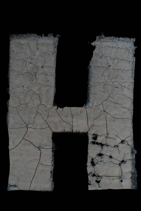 the letter h is made up of cracked concrete