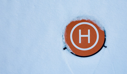 a circle with the letter h on it in the snow