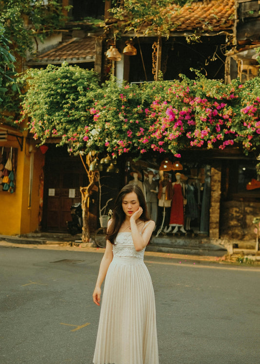 a woman in a white dress standing in front of a building
