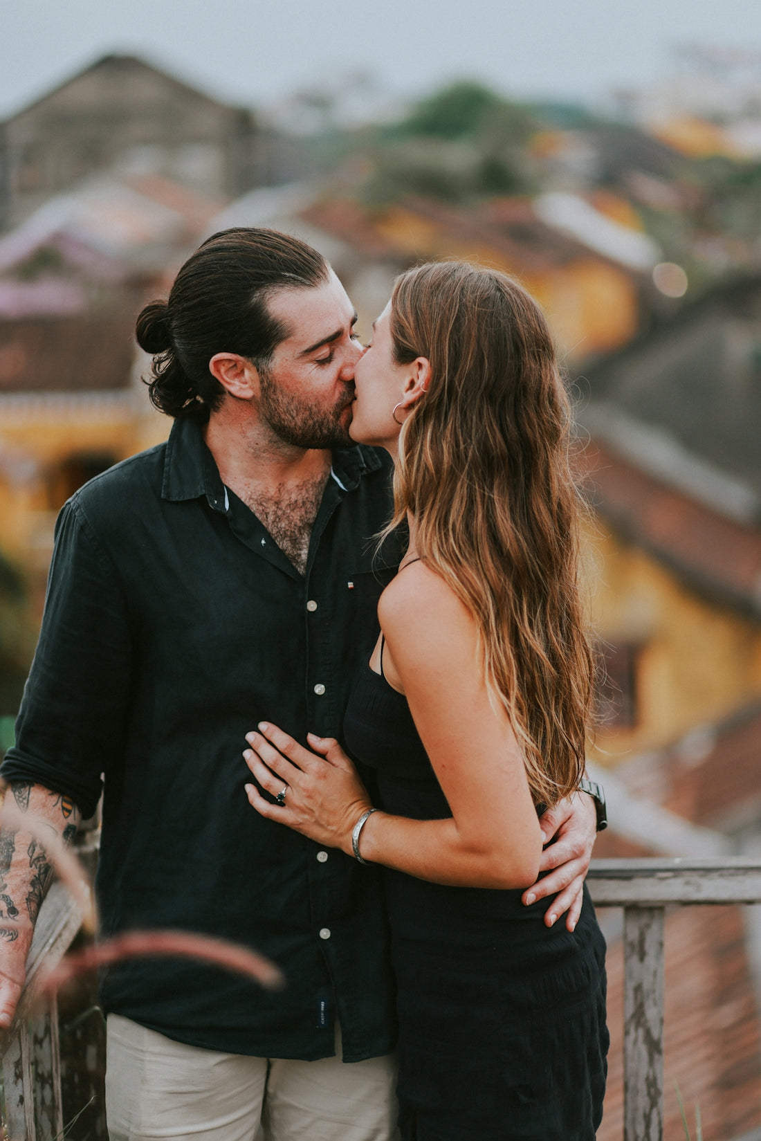 a man and a woman kissing on a balcony