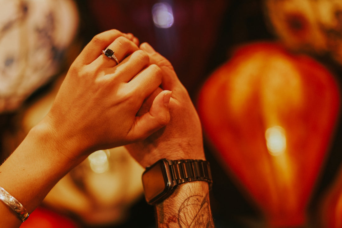 two people holding hands in front of a clock