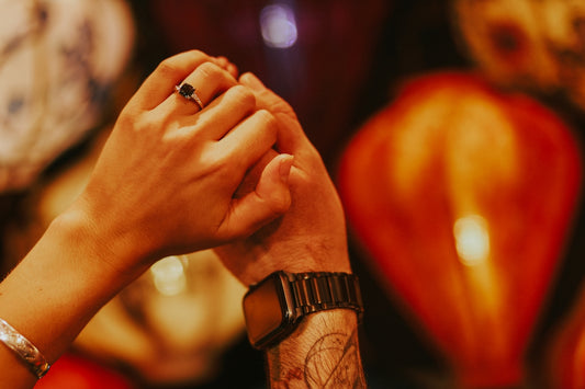 two people holding hands in front of a clock