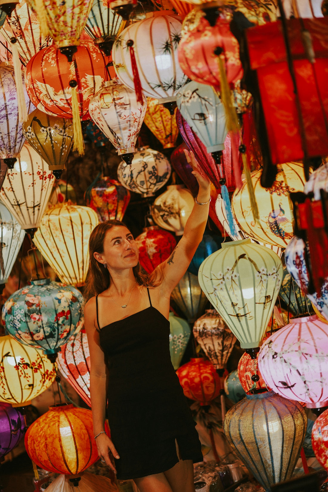 a woman standing in front of a display of lanterns