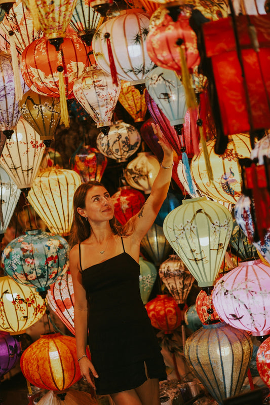 a woman standing in front of a display of lanterns