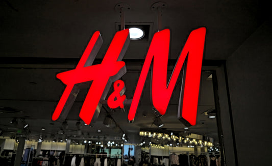 The illuminated h&m logo glows brightly at night.