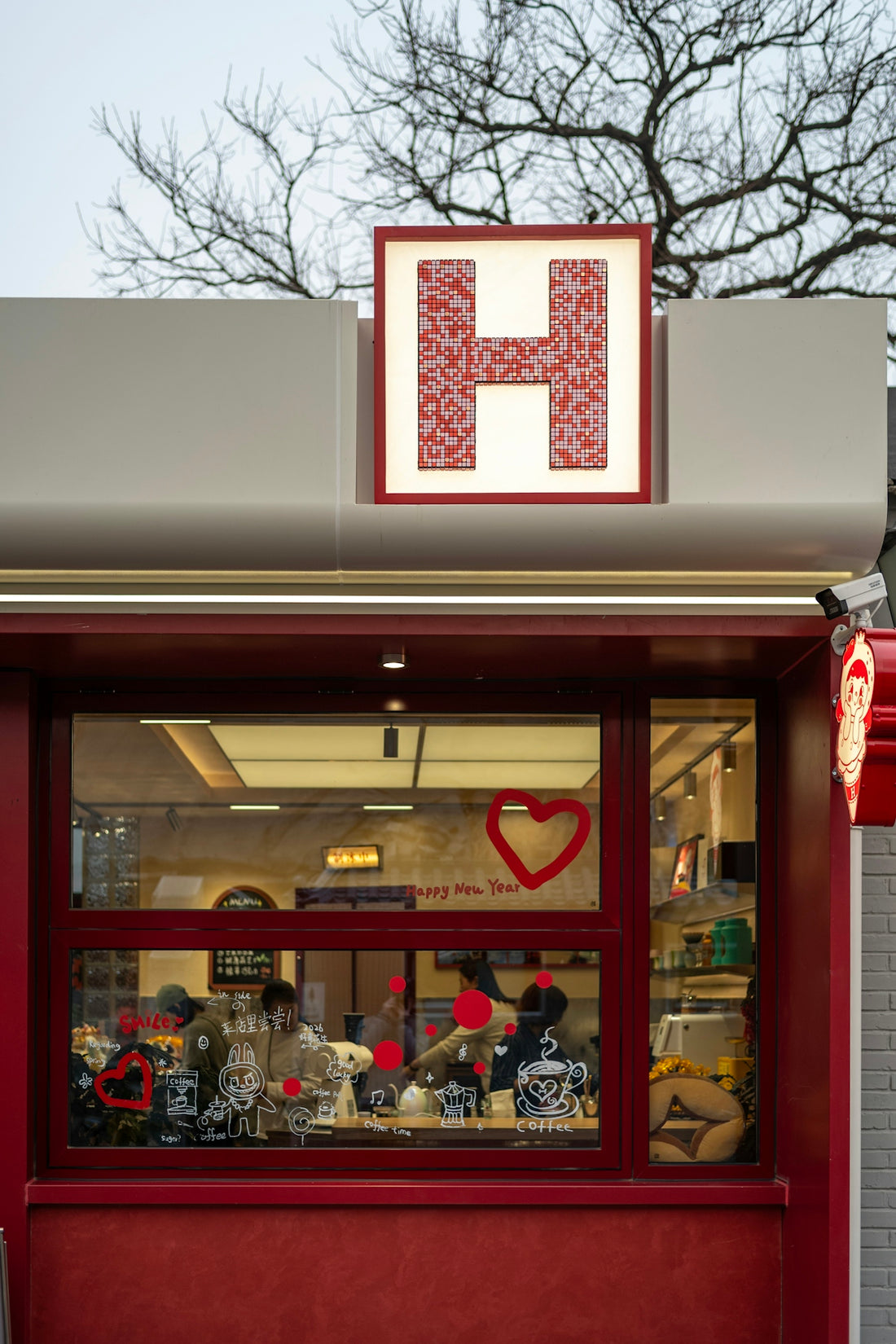 Red storefront with large letter h sign and heart decorations